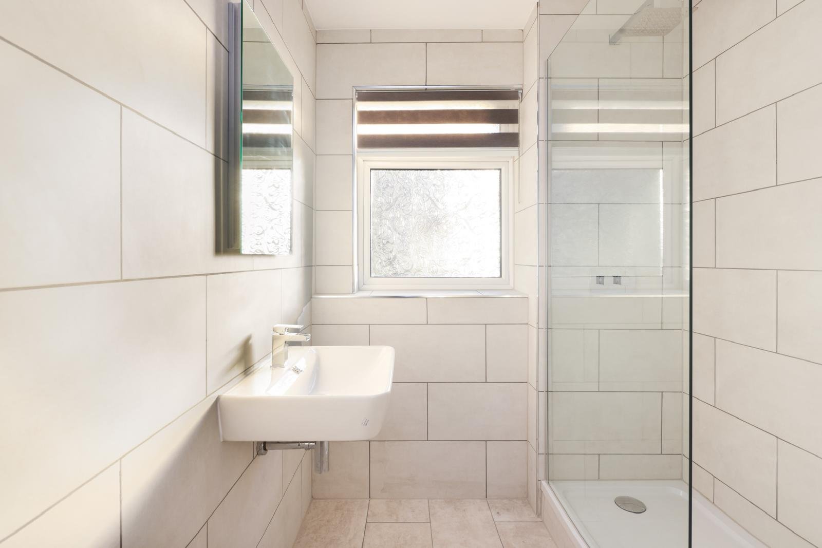 Luxury panelled bathroom with black-framed walk-in shower in London