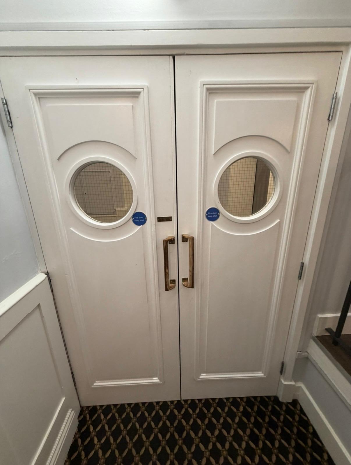 Communal fire doors with vision panels and compliant signage