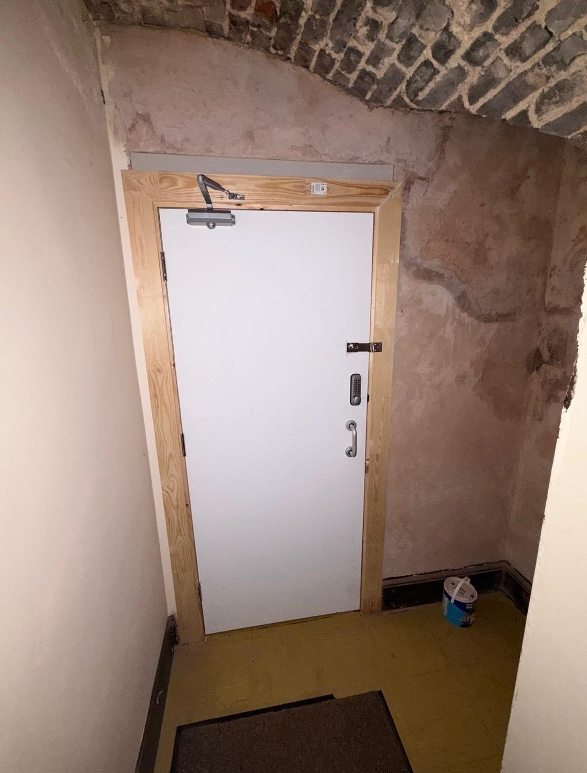 Newly installed certified fire door with closer and keypad lock